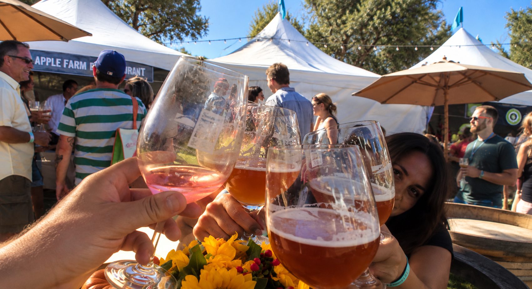 Glasses of wine and beer raised in a toast at the Atascadero Lakeside Wine Festival